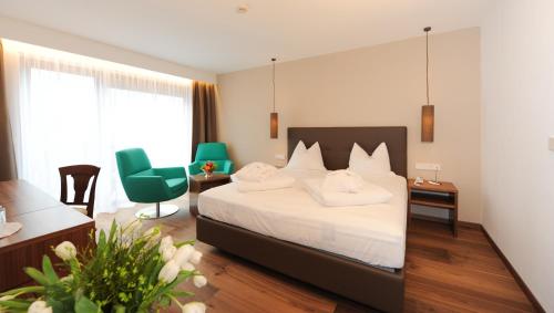 um quarto de hotel com uma cama, uma secretária e cadeiras em Hotel Vier Jahreszeiten em Silandro