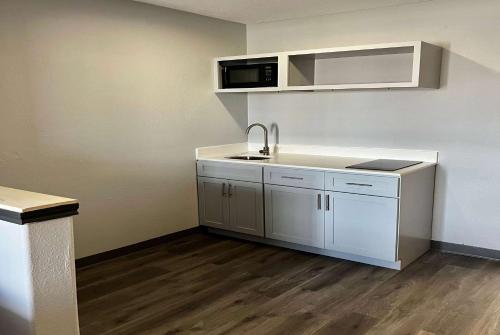 an empty kitchen with a sink and a microwave at Super 8 by Wyndham Sealy in Sealy