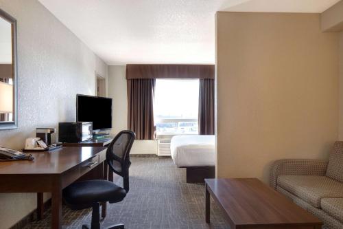 a hotel room with a desk and a bed at Days Inn & Suites by Wyndham Yorkton in Yorkton