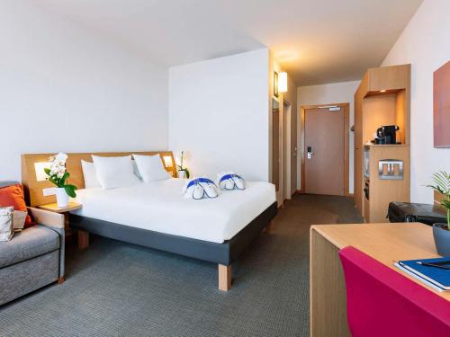 een hotelkamer met een groot bed en een bank bij Novotel Venezia Mestre Castellana in Mestre