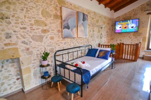 ein Schlafzimmer mit einem Bett in einer Steinmauer in der Unterkunft Villa Anastasia Luxe with Top WiFi, BBQ & Amazing Views in Kissamos