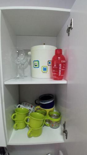 a cupboard with a bunch of green cups and dishes at Flat Recanto do Sertão in Piranhas