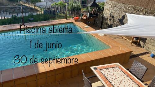 une piscine avec un panneau indiquant i do juninho dans l'établissement La casa de las Flores de El Hornillo, à El Hornillo