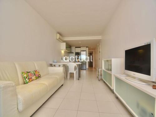 uma sala de estar com um sofá e uma televisão de ecrã plano em Catalunya E-2 em Platja d'Aro