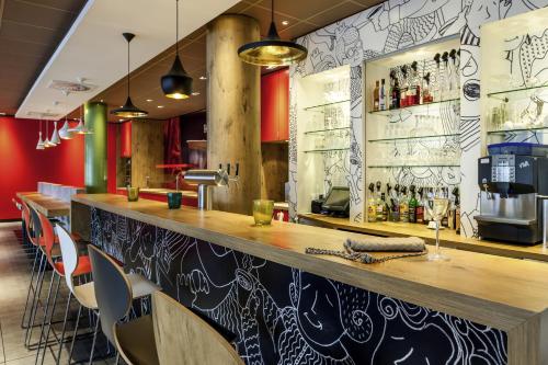 eine Bar mit einer Holztheke und Stühlen in der Unterkunft Hotel Ibis Milano Ca' Granda in Mailand