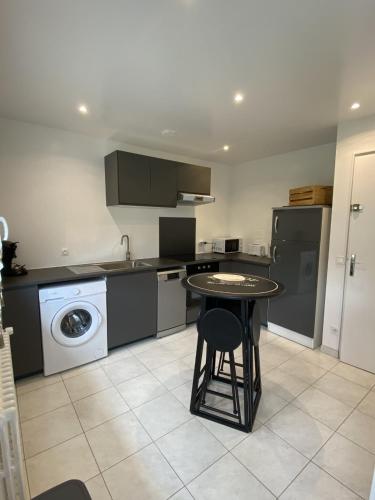 a kitchen with a table and a washing machine at Gite du Centaure in Vigny