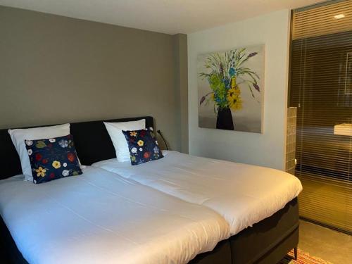 een slaapkamer met een groot bed met kussens erop bij Bed & breakfast 23 in Amerongen