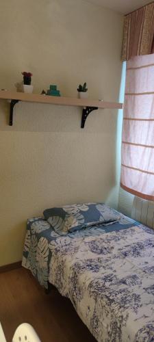 1 dormitorio con cama y estante en la pared en Habitacion individual en apartamento céntrico, en Madrid