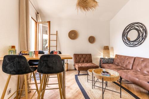 un salon avec un canapé, une table et des chaises dans l'établissement Maisonnette biscarosse, à Biscarrosse