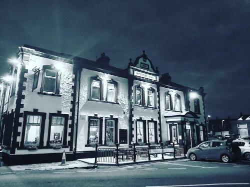 a large white building with a car parked in front of it at The Waterford Arms in Hartley