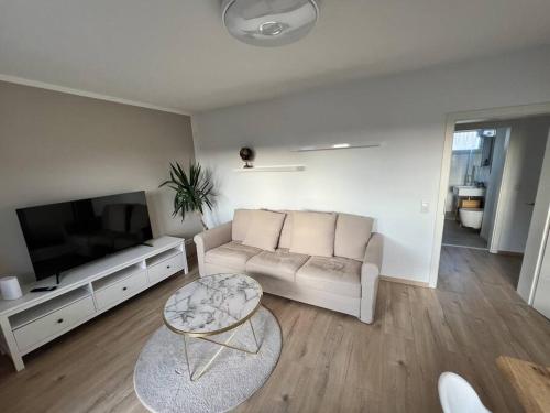 ein Wohnzimmer mit einem Sofa und einem Flachbild-TV in der Unterkunft Zwischen BVB Stadion und UNI in Dortmund