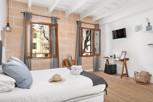 a bedroom with a bed with a hat on it at Hotel Boutique Ses 5 Claus in Ciutadella