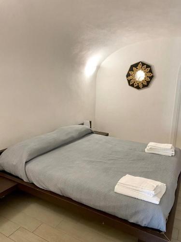 una camera da letto con un letto con un orologio sul muro di Fontania n.9 a Gaeta