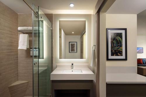 a bathroom with a sink and a glass shower at Hyatt House Monterrey Valle San Pedro in Monterrey