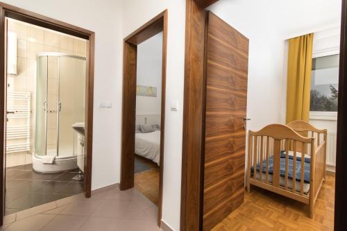 La salle de bains est pourvue d'une porte menant à une chambre. dans l'établissement APARTMAN RUPČIĆ, à Vinkovci