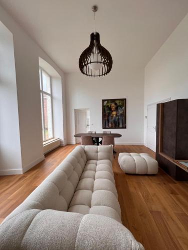 - un salon avec un grand canapé en face d'une télévision dans l'établissement Appartement château de Lewarde, à Douai