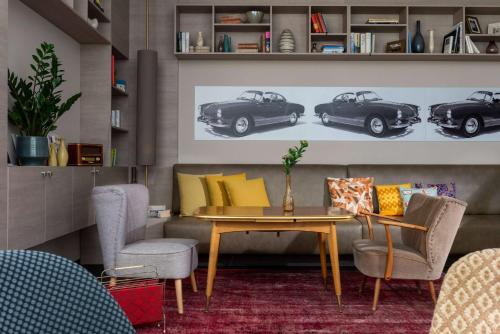 a living room with a table and three cars on the wall at Vienna House Easy by Wyndham Osnabrück City & Apartments in Osnabrück
