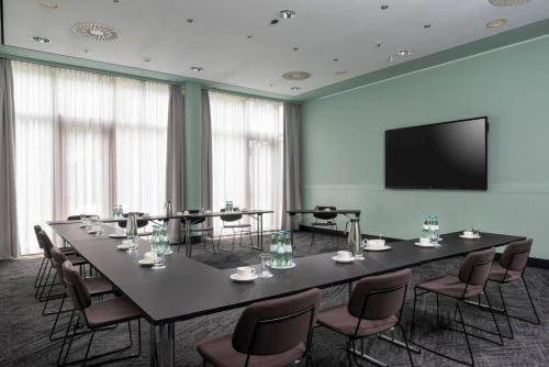 a conference room with a large table and chairs at Vienna House by Wyndham Remarque Osnabrück in Osnabrück
