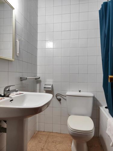 a bathroom with a toilet and a sink at Hostal Restaurante Venta del Barro in La Puebla de Híjar