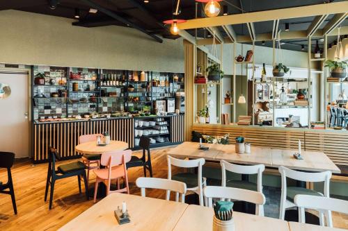 a restaurant with wooden tables and chairs at Vienna House by Wyndham MQ Kronberg in Kronberg im Taunus