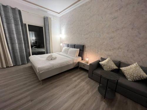 una habitación de hotel con una cama y un sofá en Sunset Sea view Studio, en Ras al Khaimah