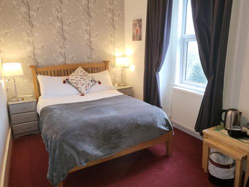 a bedroom with a bed and a window at Maridon House in Oban