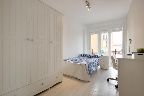 1 dormitorio con 1 cama, vestidor y escritorio en Apartment Capuchinos, en Málaga