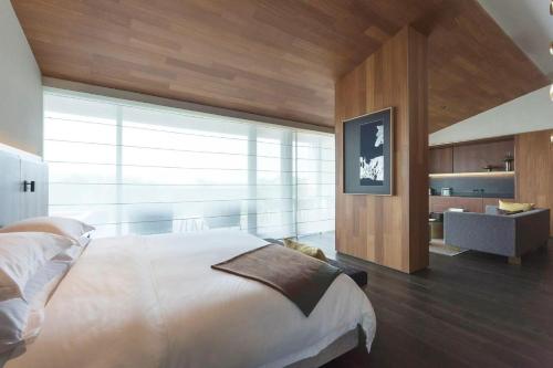 a bedroom with a large bed and a large window at MUH SHOOU XIXI HOTEL HANGZHOU in Yuhang