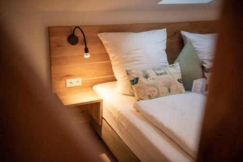 a small bedroom with a bed with a night stand and a lamp at Forstgut - Premium Waldchalets und Lodge Suiten in Regen