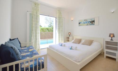 a bedroom with a bed and a large window at Villa Sa Ràpita / Es Trenc in Campos
