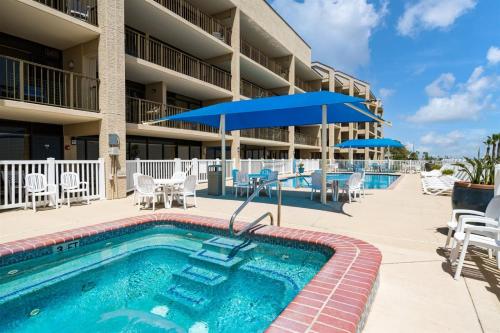 a pool at a resort with chairs and umbrellas at Laguna Reef #205 - La Las in Rockport