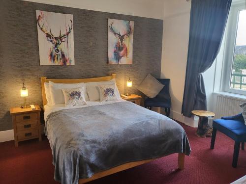 a bedroom with a bed and two lamps and a window at Maridon House in Oban