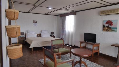 Habitación de hotel con cama y TV en RADAMA Hotel, en Antananarivo
