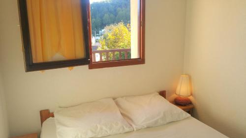 a bedroom with a bed with a window and a lamp at Résidence Cap Azur Appartement 108 in Villeneuve-Loubet