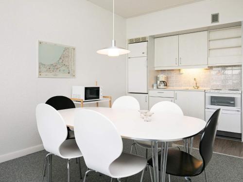 a white dining room with a white table and chairs at 6 person holiday home on a holiday park in Blokhus in Blokhus