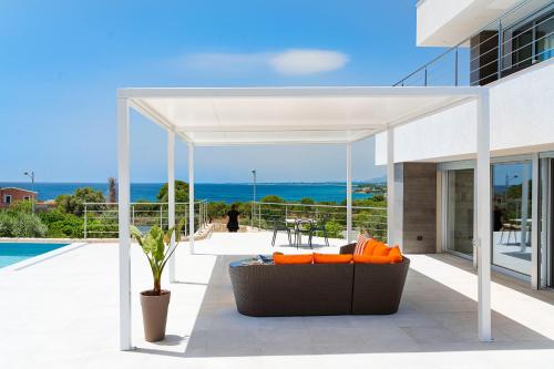 a pergola on a patio with a view of the ocean at Villa Anna in Siracusa