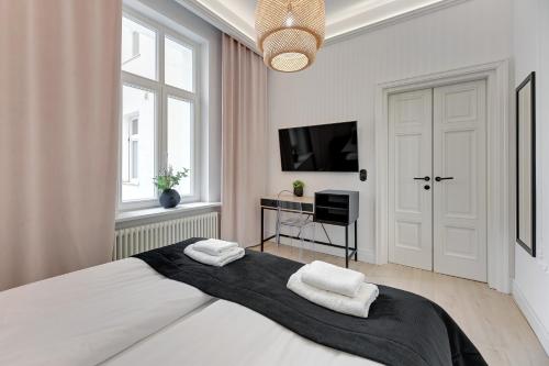 a bedroom with a large bed with two towels at Sopot Monte Cassino by Downtown Apartments in Sopot