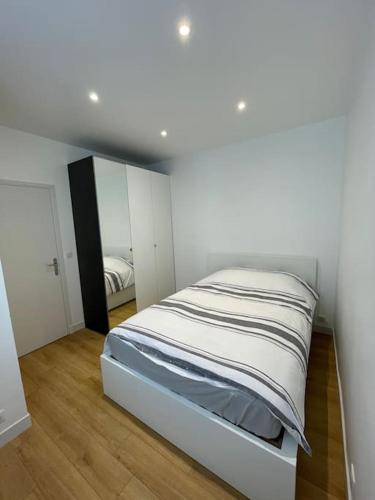 une chambre blanche avec un lit et un miroir dans l'établissement Paris Centre CLAMART Hôpital PERCY APPART 2 pièces TRÈS Lumineux Grand, à Clamart