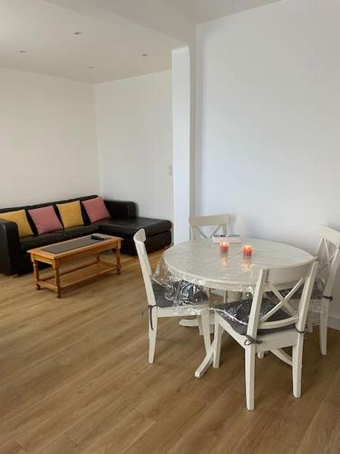 un salon avec une table, des chaises et un canapé dans l'établissement Paris Centre CLAMART Hôpital PERCY APPART 2 pièces TRÈS Lumineux Grand, à Clamart