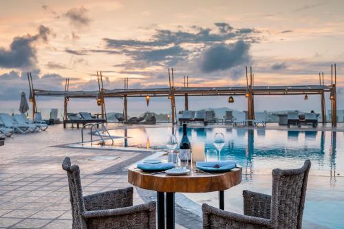 una mesa con copas de vino junto a una piscina en Orizontes Hotel Santorini en Pirgos