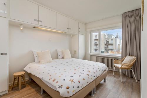 um quarto com uma cama grande e uma janela em Flat Julien em De Panne