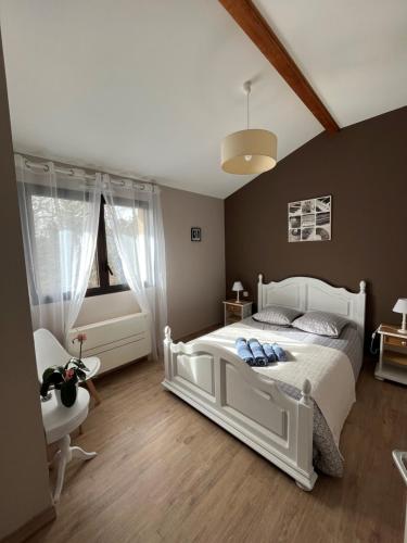 a bedroom with a white bed and a chair at Le chat perché in Saint-Julien-en-Born