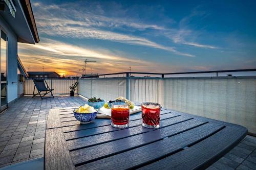a wooden table with two drinks on a patio at Il terrazzo sul tramonto in Bastiglia