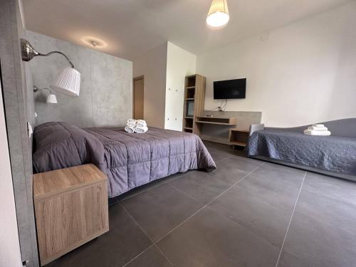 a hotel room with two beds and a television at Frontemare Hotel Village & Ristorante in Rodi Garganico
