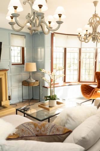 a living room with a chandelier and a table at Valesmoor Farm in New Milton