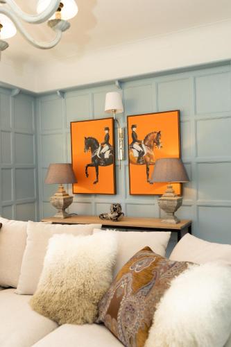 a living room with orange pictures of horses on the wall at Valesmoor Farm in New Milton