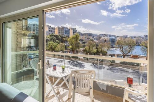 einen Balkon mit Aussicht, einem Tisch und Stühlen in der Unterkunft Stunning - SunnySide 3-Bedroom in Sliema