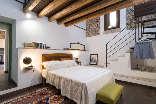 1 dormitorio con 1 cama grande y una escalera en Baglio Maranzano - Don Carlo, en Buseto Palizzolo