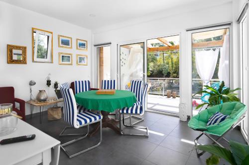 a living room with a green table and chairs at Ínsua Hostel in São Pedro do Sul