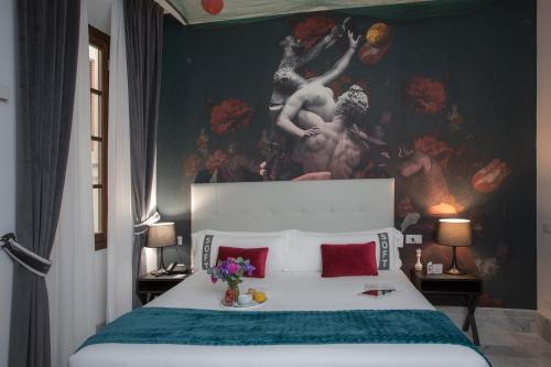a bedroom with a large bed with a painting on the wall at Casual Rinascimento Firenze in Florence